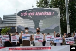 Protesters stage a rally to oppose the joint military exercises between the U.S. and South Korea in front of the presidential office in Seoul, South Korea, Monday, Aug. 22, 2022. (AP Photo/Ahn Young-joon)