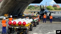 Military personnel stand next to Harpoon A-84, anti-ship missiles and AIM-120 and AIM-9 air-to-air missiles prepared for a weapon loading drills in front of a F16V fighter jet at the Hualien Airbase in Taiwan, Aug. 17, 2022. (AP Photo/Johnson Lai)