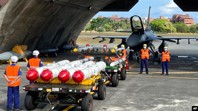 Military personnel stand next to Harpoon A-84, anti-ship missiles and AIM-120 and AIM-9 air-to-air missiles prepared for a weapon loading drills in front of a F16V fighter jet at the Hualien Airbase in Taiwan, Aug. 17, 2022. (AP Photo/Johnson Lai)