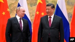 FILE - Chinese President Xi Jinping and Russian President Vladimir Putin speak in Beijing, Feb. 4, 2022. 