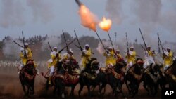 FILE: A troupe charges and fires their rifles during Tabourida, a traditional horse riding show also known as Fantasia, in Rabat, Morocco, Aug. 27, 2022. 
