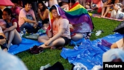 Participants of Pink Dot, an annual event organized in support of the LGBT community, shelter themselves from the rain with a gay pride flag at the Speakers' Corner in Hong Lim Park in Singapore, June 29, 2019.