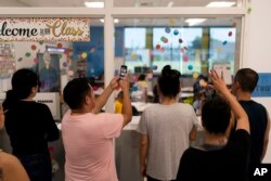 Para orang tua murid kelas 1 SD Sunkist di Anaheim, California tengah mengamati anak-anak mereka di hari pertama sekolah (dok: AP/Jae C. Hong)