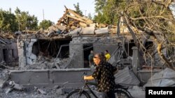 Un hombre camina con su bicicleta frente a las casas destruidas por un ataque, en medio de la invasión de Rusia, en Mykolaiv, Ucrania, el 29 de agosto de 2022.