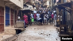 Des manifestants crient face à la police anti-émeute lors de manifestations anti-gouvernementales à Freetown, en Sierra Leone, le 10 août 2022.