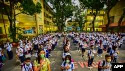 Students attend a flag-raising ceremony before singing the national anthem on the first day of in-person classes after pandemic lockdowns at Pedro Guevara Elementary School in Manila on Aug. 22, 2022. 