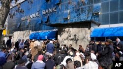 FILE - People wait to enter a bank, in Kabul, Afghanistan, Feb. 13, 2022. 