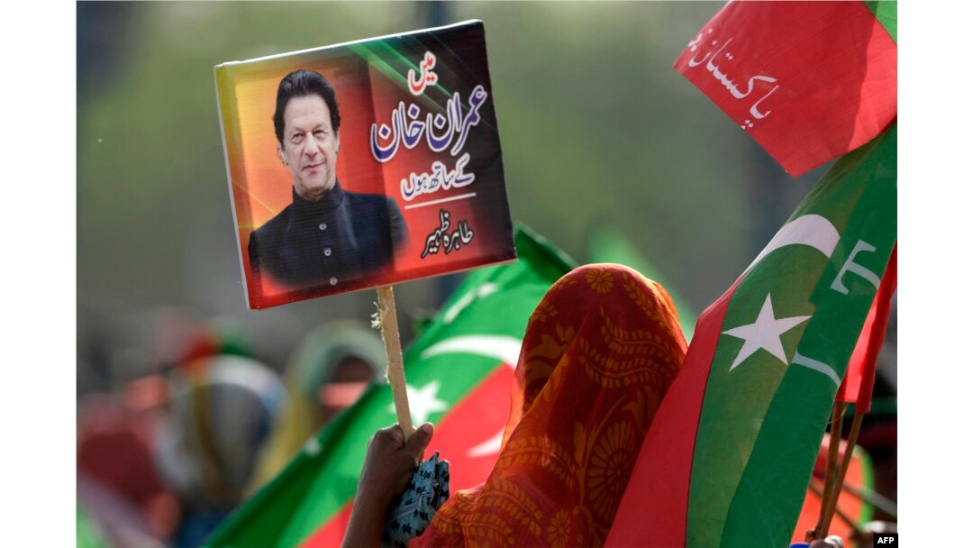 Seorang pendukung partai berkuasa Pakistan Tehreek-e-Insaf (PTI) memegang plakat bergambar mantan perdana menteri Pakistan Imran Khan pada 27 Maret 2022. (Foto: AFP/Aamir QURESHI)