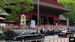 FILE - The vehicle carrying the body of former Japanese Prime Minister Shinzo Abe leaves Zojoji temple after his funeral in Tokyo on July 12, 2022.