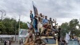 Taliban fighters celebrate one year since they seized the Afghan capital, Kabul, in front of the U.S. Embassy in Kabul, Afghanistan, Monday, Aug. 15, 2022. The Taliban marked the first-year anniversary of their takeover after the country's western-backed 