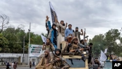 Taliban fighters celebrate one year since they seized the Afghan capital, Kabul, in front of the U.S. Embassy in Kabul, Afghanistan, Aug. 15, 2022. 