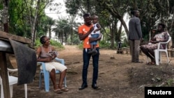 Musa Pabai holds his son Oliver for the first time after surviving Ebola, at his home in Walakor, February 19, 2015