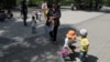 資料照片：北京一所公園裡的兒童在成年人的看護下玩耍。 （2021年6月1日）