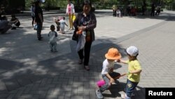 资料照：北京一所公园里的儿童在成年人的看护下玩耍。（2021年6月1日）
