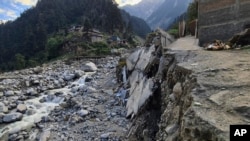 Homes and a portion of road sit destroyed by floodwaters in Kalam Valley in northern Pakistan, Aug. 30, 2022.