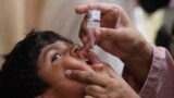 FILE - A health worker gives a polio vaccine to a child in Karachi, Pakistan, May 23, 2022. 