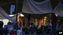 নেদারল্যান্ডের উত্তরে টের আপেলের জনবহুল অভিবাসন প্রত্যাশী কেন্দ্রে এক ব্যক্তি তারপুলিনের নিচে বসে প্রার্থনা করছেন। শতশত অভিবাসন প্রত্যাশী, কেন্দ্রের বাইরে রাত কাটানোর প্রস্তুতি নিচ্ছেন (২৫ আগস্ট, ২০২২) 