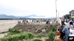 People on a bank of an overflowing stream in Mingora, the capital of Swat valley in Pakistan, Aug. 27, 2022. Flash floods have killed nearly 1,000 people.