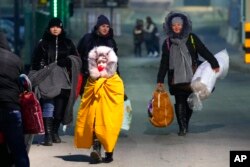 Orang-orang yang melarikan diri dari konflik di negara tetangga Ukraina melintasi perbatasan di Przemysl, Polandia, 27 Februari 2022. (Foto: AP)