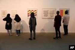 Visitors look at artworks by the American artist Sol Lewitt while visiting a 19th and 20th-century American and European minimalist and conceptual masterpieces show at the Tehran Museum of Contemporary Art in Tehran, Iran, Aug. 2, 2022.