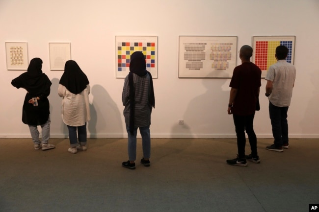 Visitors look at artworks by the American artist Sol Lewitt while visiting a 19th and 20th-century American and European minimalist and conceptual masterpieces show at the Tehran Museum of Contemporary Art in Tehran, Iran, Aug. 2, 2022.