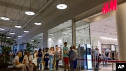 People queue to enter an H&M store and buy goods sold at the Aviapark shopping center in Moscow, Russia, August 9, 2022.