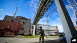 ARCHIVO - Un militar ruso hace guardia en un área de la central nuclear de Zaporizhzhia en territorio bajo control militar ruso, en el sureste de Ucrania, el 1 de mayo de 2022.