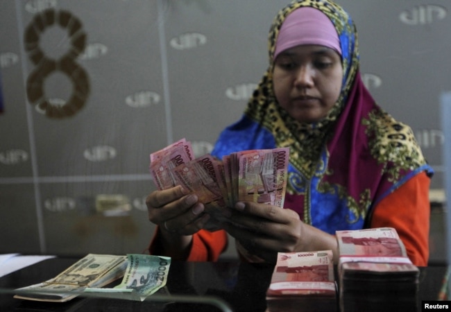 ILUISTRASI - Seorang teller bank menghitung uang kertas rupiah untuk nasabahnya di Jakarta, 26 Agustus 2015. (REUTERS/Nyimas Laula)