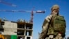 Un soldado ruso protege la ocupación de un nuevo edificio de apartamentos que se construye con el apoyo del Ministerio de Defensa de Rusia, en Mariúpol, en el territorio que está bajo el control del Gobierno de la República Popular de Donetsk, en el este 