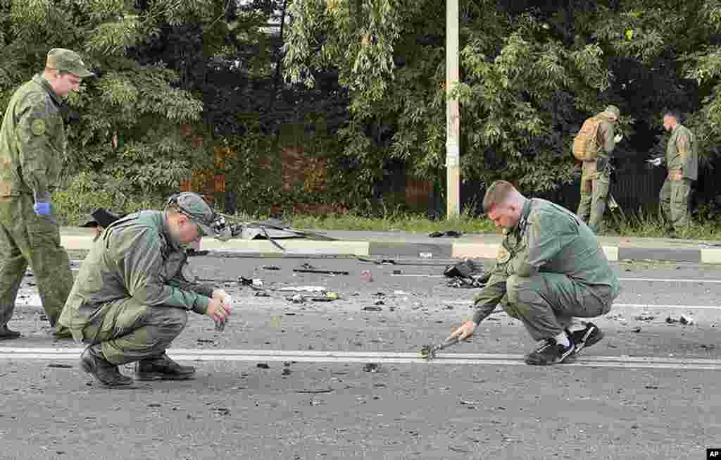 In this handout photo taken from video released by Investigative Committee of Russia, investigators work on the site of explosion of a car driven by Daria Dugina outside Moscow. Dugina, the daughter of Alexander Dugin, the Russian nationalist ideologist often called &quot;Putin&#39;s brain&quot;, was killed when her car exploded on the outskirts of Moscow, officials said.