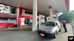 FILE - An attendant pumps fuel into a taxi at a gas station in Botahtaung township in Yangon, Myanmar, on Nov. 12, 2021. 