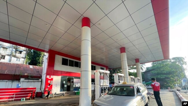 FILE - An attendant pumps fuel into a taxi at a gas station in Botahtaung township in Yangon, Myanmar, on Nov. 12, 2021.