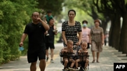 중국에서 보행자가 아이들을 태운 유모차를 밀고 있다. (자료사진)
