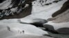 A group of people walk near a crevasse in a glacier in Sonmarg, Kashmir.