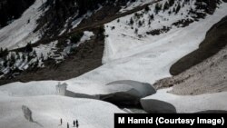 একদল লোক কাশ্মীরের সোনমার্গের একটি হিমবাহের ক্রেভাসের কাছে হাঁটছে।