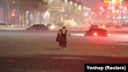 A man makes his way through flooded area during heavy rain in Seoul, South Korea, on August 8, 2022.