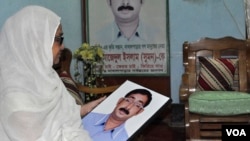 Hajera Khatun holds a photo of her son, opposition Bangladesh Nationalist Party leader Sajedul Islam Shuman, who remains missing after Rapid Action Battalion members allegedly abducted him from Dhaka in 2013. (Abdul Rajjak/VOA)