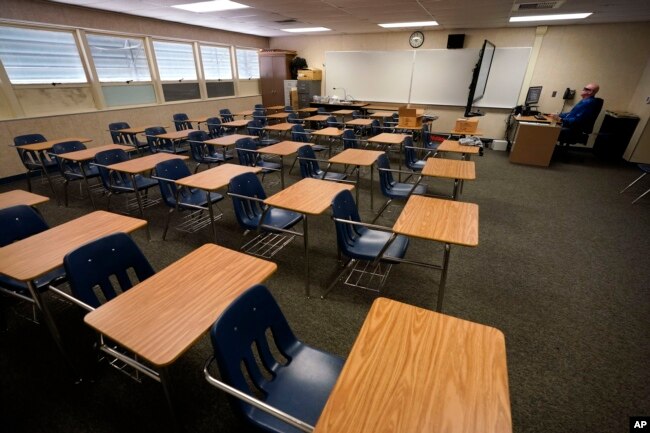 Ilustrasi - Dalam file foto 18 Agustus 2020 ini, Guru Matematika Doug Walters duduk di antara meja kosong saat konferensi video dengan guru lain untuk mempersiapkan pembelajaran di rumah di SMP Twentynine Palms di Twentynine Palms, California. (AP/Gregory Bull, File)