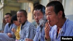 Seorang pasien gangguan jiwa merokok di halaman dalam rumah sakit yang menampung dan memberikan perawatan kepada lebih dari 500 pasien yang menderita penyakit mental, di Taiyuan, Provinsi Shanxi, 9 Oktober 2010. (Foto: Reuters)