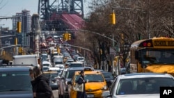 FILE - Pedestrians cross Delancey Street as traffic from Brooklyn enters Manhattan over the Williamsburg Bridge, March 28, 2019, in New York. Roadway deaths rose about 7% during the first three months of 2022 to 9,560 people, officials reported Aug. 17, 2022.