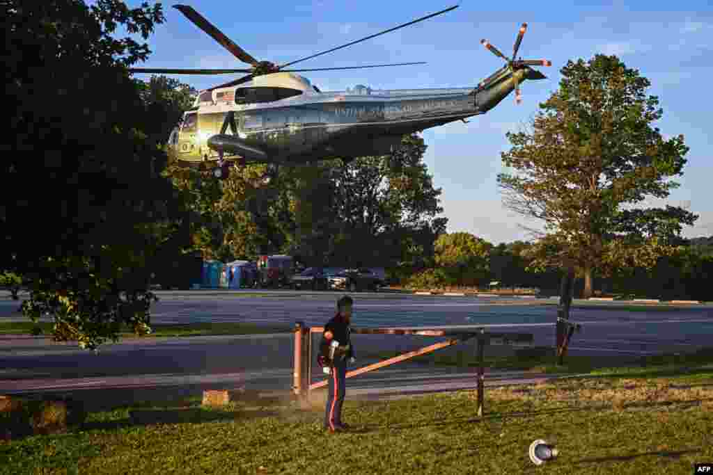 A U.S. Marines&#39; hat is blown off as U.S. President Joe Biden takes off from Brandywine Creek State Park in Marine One in Wilmington, Delaware, Aug. 20, 2022.