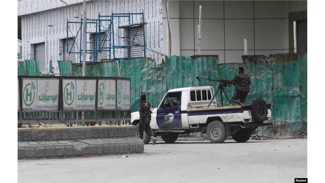 Somali police officers ride on their pick-up truck towards Hotel Hayat, the scene of an al Qaeda-linked al-Shabab group militant attack in Mogadishu, Somalia, Aug. 20, 2022.