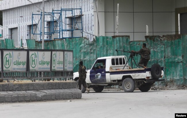 Somali police officers ride on their pick-up truck towards Hotel Hayat, the scene of an al Qaeda-linked al-Shabab group militant attack in Mogadishu, Somalia, Aug. 20, 2022.