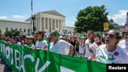 FILE - Abortion-rights activists march past the U.S. Supreme Court building to protest the court's ruling overturning the landmark Roe v.Wade abortion decision, in Washington, June 30, 2022.