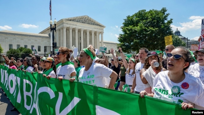 FILE - Abortion rights activists march past United States Supreme Court to protest the court's ruling overturning the landmark Roe v.Wade abortion decision, in Washington, June 30, 2022.