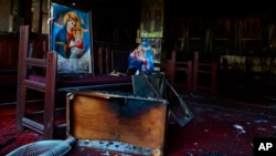 Burned furniture, including wooden tables and chairs, and religious imagery are seen at the site of a fire inside the Abu Sefein Coptic church in the densely populated neighborhood of Imbaba, Cairo, Egypt, Aug. 14, 2022.
