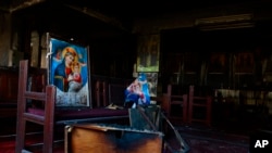 Berbagai perabotan tampak hangus terbakar, termasuk meja dan kursi kayu, serta ornamen-ornamen keagamaan terlihat di lokasi kebakaran di dalam gereja Koptik Abu Sefein di lingkungan padat penduduk Imbaba, Kairo, Mesir, Minggu 14 Agustus 2022.
