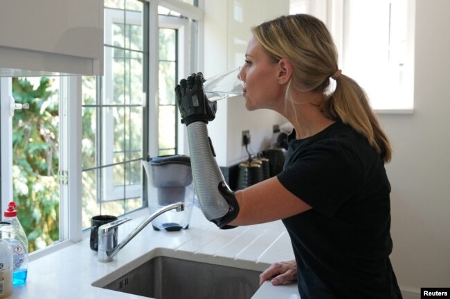 Jessica Smith, a former Australian Paralympic Swimmer, tests her new bionic hand that improves the speed of movement and sensitivity of touch, according to the company, in London, Britain August 12, 2022. (REUTERS/Maja Smiejkowska)