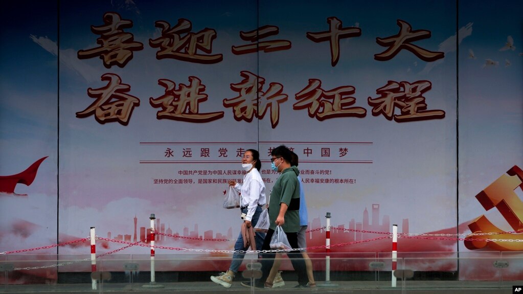 行人走过北京街头竖立的中共二十大宣传牌。（2022年8月17日）(photo:VOA)