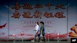 行人走过北京街头竖立的中共二十大宣传牌。（2022年8月17日）